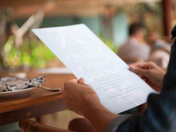 Speisekarte - warum Sie so wichtig ist - Mann hält eine Speisekarte in der Hand