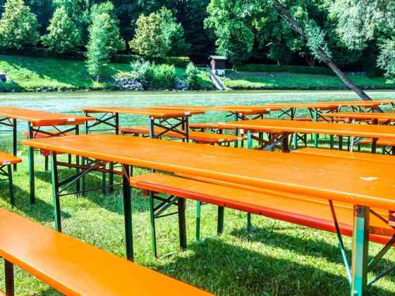 Festzeltgarnitur kaufen: Bierzeltgarnituren auf einer Wiese am Fluss
