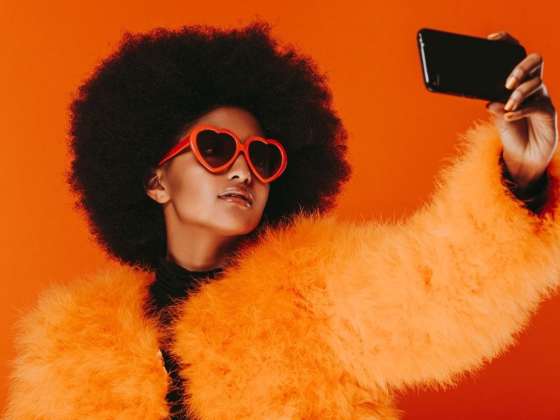 Generation Instagram: So werden Sitzplätze zum Markenerlebnis - Frau mit auffälligem Look die ein Selfie macht