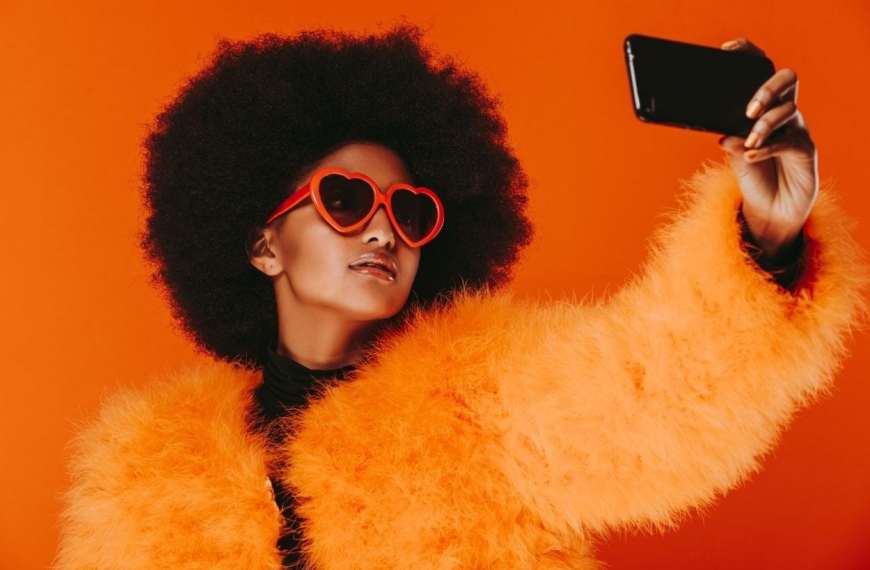 Generation Instagram: So werden Sitzplätze zum Markenerlebnis - Frau mit auffälligem Look die ein Selfie macht